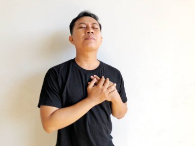 Göğsünde elleri olan siyah tişörtlü bir adam..