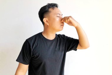 Beyaz arka planda soyutlanmış, başı ağrıyan Asyalı genç bir adam.