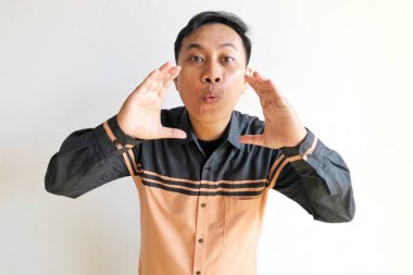 Asyalı adam yüzünde komik bir jest yapıyor.