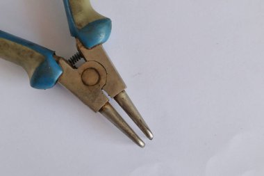 Beyaz arka planda vidaları olan metal bir tornavida.