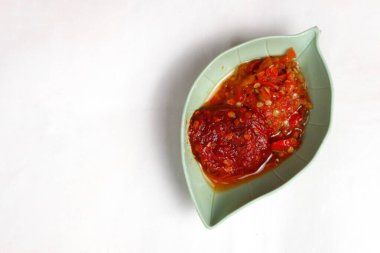 Geleneksel Endonezya acı biberi sosu. Beyaz arka planda izole edilmiş bir kasede servis edilen karides ezmesi, sarımsak, arpacık soğanı ve baharat.