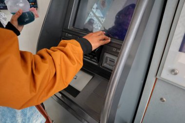 Jepara, 13 Ekim 2024 - Asyalı bir kadının eli Jateng Bankası 'ndaki ATM veya para çekme makinesinden para çekti