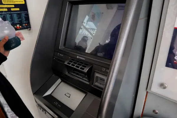 Jepara, 13 Ekim 2024 - Asyalı bir kadının eli Jateng Bankası 'ndaki ATM veya para çekme makinesinden para çekti