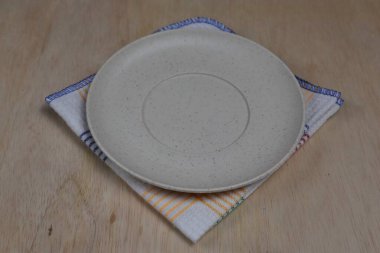 Boş tabak, tahta üstüne bez.