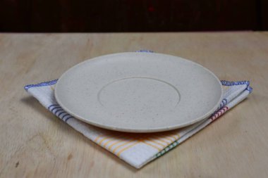 Boş tabak, tahta üstüne bez.