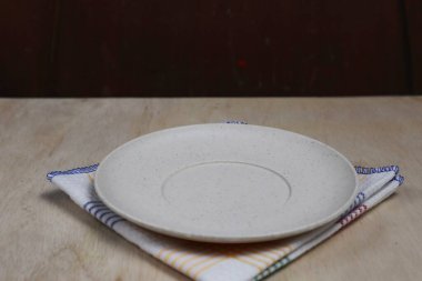 Boş tabak, tahta üstüne bez.