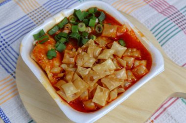 Hamur köftesi ve taze soğanla kaplı baharatlı chili wonton.