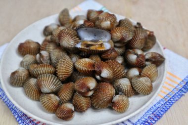 Taze midyeler, kaynamış istiridyeler, beyaz bir tabakta servis edilen kolay bir deniz ürünleri tarifi menüsü, kan midyeleri.