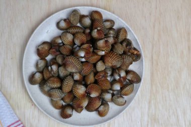 Taze midyeler, kaynamış istiridyeler, beyaz bir tabakta servis edilen kolay bir deniz ürünleri tarifi menüsü, kan midyeleri.