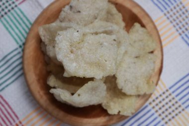 Ahşap bir tabakta servis edilen jengkol krakerlerinin yakın çekimi