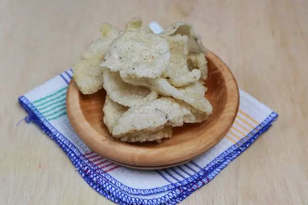 Ahşap bir tabakta servis edilen jengkol krakerlerinin yakın çekimi