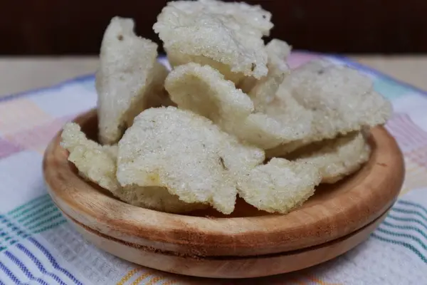 Ahşap bir tabakta servis edilen jengkol krakerlerinin yakın çekimi