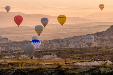 Büyülü Şafak: Kapadokya 'nın Peri Bacalarının Üzerinde Gün Doğumu. Kapadokya, Türkiye 'nin Merkez Anadolu kentinde eşsiz manzarası, yeraltı şehirleri, mağara evleri ve peri bacalarıyla tanınan tarihi bir bölgedir.. 