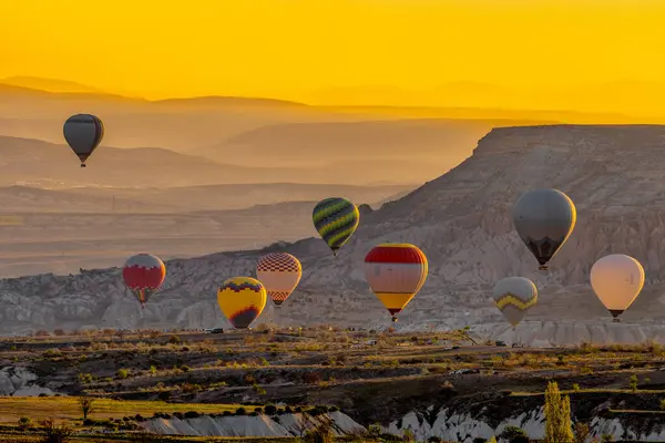 Büyülü Şafak: Kapadokya 'nın Peri Bacalarının Üzerinde Gün Doğumu. Kapadokya, Türkiye 'nin Merkez Anadolu kentinde eşsiz manzarası, yeraltı şehirleri, mağara evleri ve peri bacalarıyla tanınan tarihi bir bölgedir.. 