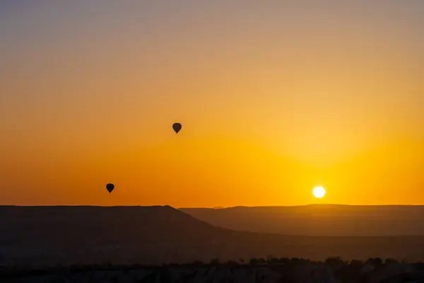 Büyülü Şafak: Kapadokya 'nın Peri Bacalarının Üzerinde Gün Doğumu. Kapadokya, Türkiye 'nin Merkez Anadolu kentinde eşsiz manzarası, yeraltı şehirleri, mağara evleri ve peri bacalarıyla tanınan tarihi bir bölgedir.. 