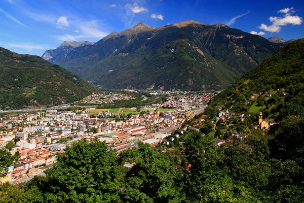 Landscape with a view of the mountains, the town of Bellinzona at their feet and the small yellow church, in Bellinzona, near Locarno, in southern Switzerland
