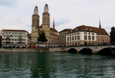 Zürih, İsviçre - 08.30.2018: Grossmunster Katedrali, Munsterbrucke kemer köprüsü ve İsviçre 'nin Zürih kentindeki Limmat nehir setinin manzaralı fotoğraf