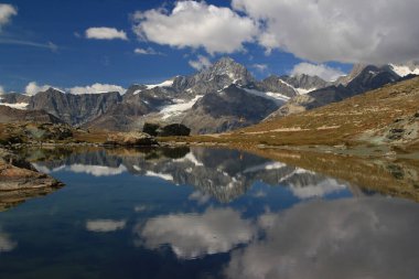 Rifelsee gölü yüzeyi pürüzsüz, dağları ve bulutları Güney İsviçre 'de Zermatt yakınlarında Gornergrat Dağı' na yansıyan bir manzara.