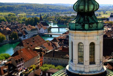 Solothurn, Switzerland-09.09.2018: Photo with the view of  the dome of Solothurn Cathedral and the Are river embankment with bridges in the city of Solothurn, near Bern in Switzerland clipart