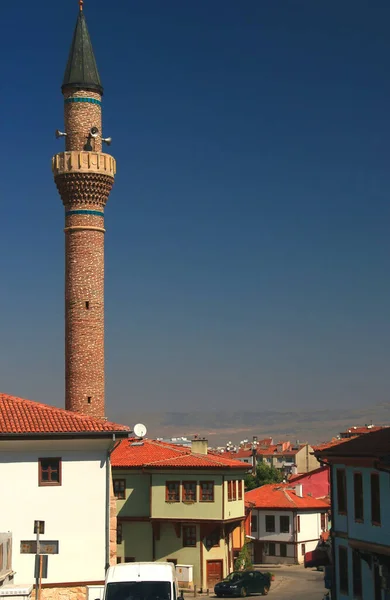 图为土耳其埃斯基希尔历史中心一条狭窄的街道 有五彩斑斓的房屋和一座清真寺尖塔 — 图库照片