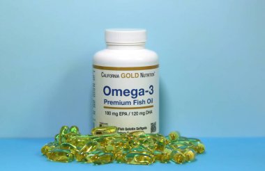 Kyiv, Ukrayna - 30 Nisan 2023: Omega-3 vitaminlerinin şişe ve kapsülleri Kaliforniya Altın Besin tarafından açık mavi arka planda üretildi