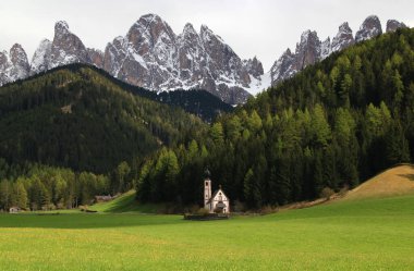 Ranui 'deki Chiesa di San Giovanni manzaralı manzara, İtalya' nın Ortisei, Santa Magdalena kentindeki Puez Odle Ulusal Parkı 'nın arka planında yer alıyor.