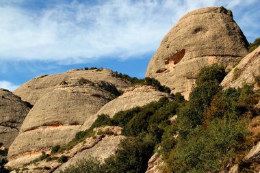 Montserrat Manastırı, Barselona, Katalonya, İspanya yakınlarındaki Ulusal Parkı 'nda bulutlu mavi gökyüzüne karşı dağlarla yakın manzara