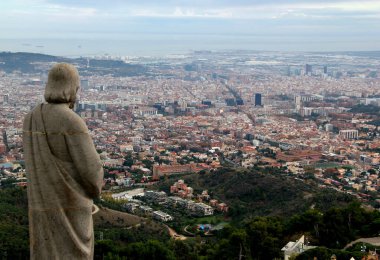 Barselona, Katalonya, İspanya - 20 Kasım 2021: Tibidabo Tepesi 'ndeki Kutsal Yürek Tapınağı' nın ön planında dini bir heykel bulunan Barcelona kentinin panoramik manzarası