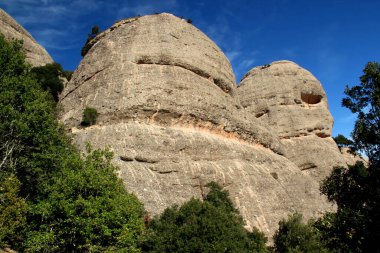 Barcelona, Katalonya, İspanya yakınlarındaki Montserrat manastırı yakınlarındaki Ulusal Parkı 'nda bulutlu mavi bir gökyüzüne karşı dağlarla manzara