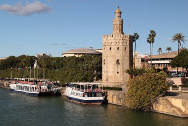 Seville, İspanya - 02 Aralık 2021: Torre del Oro Kulesi ve Guadalquivir Nehri manzaralı fotoğraf Seville, Endülüs bölgesinin tarihi merkezinde teknelerle gezinti