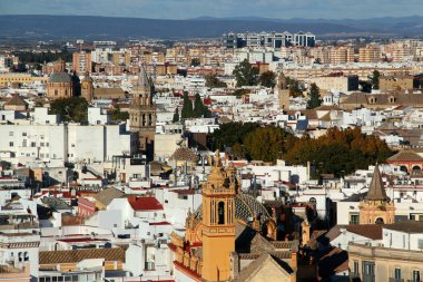 Güney İspanya 'nın Endülüs bölgesindeki dağların arka planında çan kuleleri bulunan sayısız kilisesi olan Seville şehrinin panoramik bir görüntüsü.