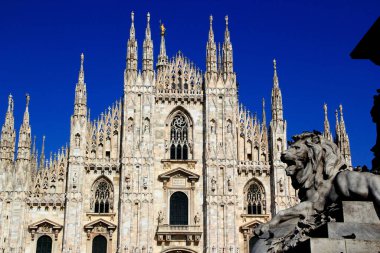 Milan, İtalya - 14 Mayıs 2019: Duomo di Milano Katedrali 'nin cephesi ve anıtın ön planda bir aslan olan II. Vittorio Emanuele anıtı görüntüsü