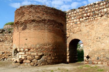 Türkiye 'nin İznik kentinde mavi bulutlu bir gökyüzüne karşı kentin tarihi bölümünü çevreleyen yuvarlak kuleli kapılardan birinin manzarası