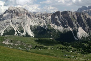 Ortisei, Dolomitler, Güney Tyrol Bölgesi, İtalya 'da bulutlu bir gökyüzüne karşı bir sıradağ manzarası fotoğrafı