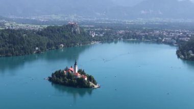 Slovenya 'nın Ljubljana kenti yakınlarında bir ada ve kilise bulunan dağların ve Bled Gölü' nün video panoraması