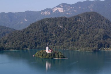 Dağların panoramik manzarası ve Slovenya 'nın Ljubljana kenti yakınlarında bir ada ve bir kilise ile Bled Gölü