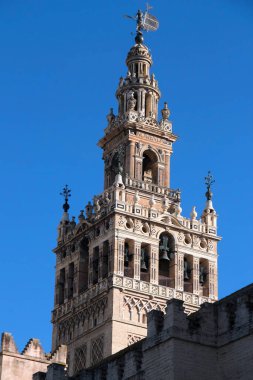 Seville, İspanya - 02 Aralık 2021: Fotoğraf: Sevilla Katedrali 'nin çan kulesi manzaralı - La Giralda kulesi mavi gökyüzüne karşı
