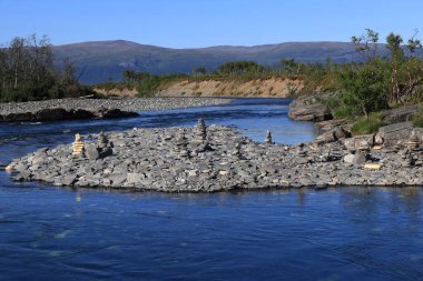 İsveç 'in kuzeyindeki Abisko Ulusal Parkı' nda Abisko Kanyonu 'nun arka planında dağları olan bir nehrin manzara fotoğrafı.