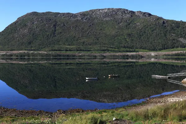 Norveç 'teki Lofoten Adaları' ndaki sulara yansıyan gölün ayna yüzeyi ve arka planda dağların olduğu manzara fotoğrafı.