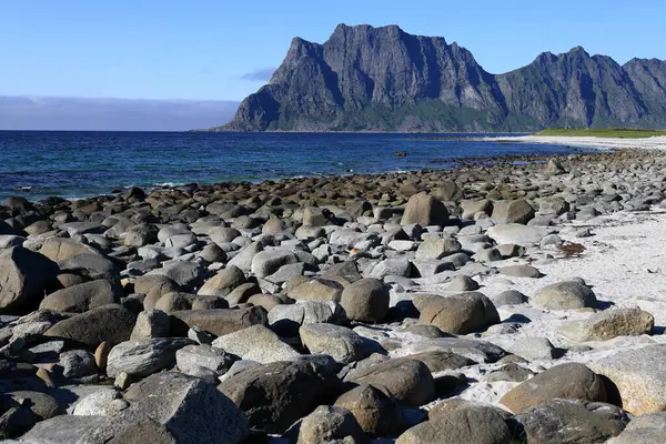 Norveç 'in Lofoten Adaları' ndaki Uttakleiv plajında, Norveç Denizi 'nin bir körfezi ve taşların manzaralı bir manzara fotoğrafı.