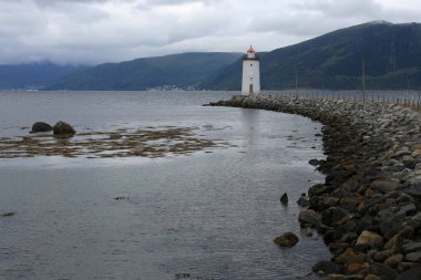 Landscape photo with a view of the mountains, sea and the Hgsteinen Lighthouse early in the morning in the village of Godoya, near lesund in Norway
