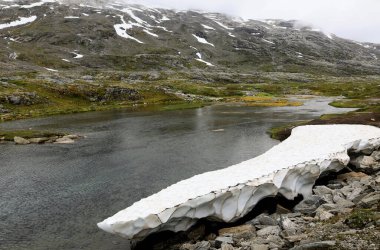Djupvatnet Gölü, Geiranger, Norveç üzerinde kısmen bulutlarla kaplı bir dağ manzaralı yaz manzarası fotoğrafı.