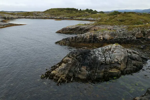 Landscape photo with a view of the Norwegian Sea rocky coast against a cloudy sky near Molde in Norway