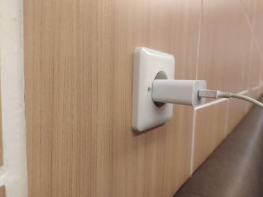 Bir prize takılı cep telefonu şarj aletinin kablosunu kapat