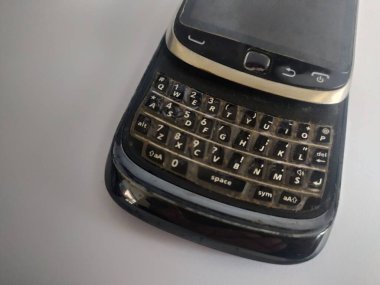 eski siyah cep telefonu, beyaz arkaplanda klavye kaydırması
