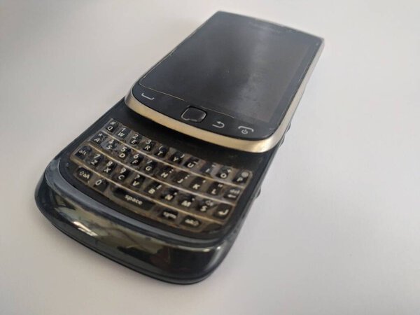 старый черный телефон, клавиатура слайд на белом фоне
