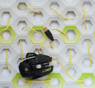 Yellow and black mouse with connector USB on white and green honeycomb background