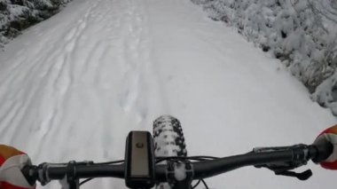 Şişman bir bisikletle karda bisiklet sürmek.