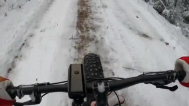 Şişman bir bisikletle karda bisiklet sürmek.