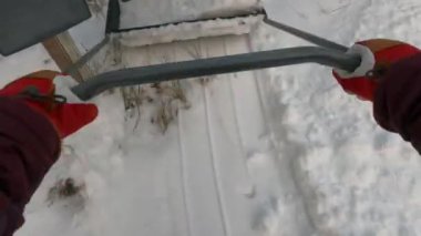 Bir kar küreğiyle bahçede kar kusuyordu.